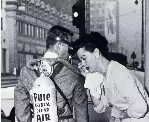 1958年，洛杉矶。连续3 天雾霾之后，一位女士正擦拭不断流泪的眼睛。她准备呼吸一瓶由城外采集的新鲜空气。瓶身上写着“如水晶般透明的空气”。